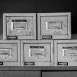 A set of five vintage metal file cabinets, aged and worn, displayed in black and white. - Photo by Magda Ehlers on Pexels