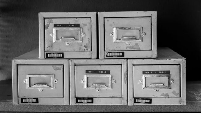 A set of five vintage metal file cabinets, aged and worn, displayed in black and white. - Photo by Magda Ehlers on Pexels