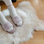 Warm and cozy feet in plush slippers resting on a soft fur rug for relaxation. - Photo by https://kaboompics.com/ on Pexels
